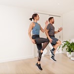 Two people exercising at home watching a video class